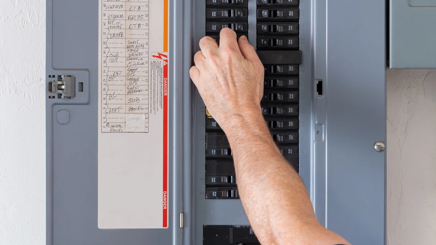 A person checks the breakers in a service panel