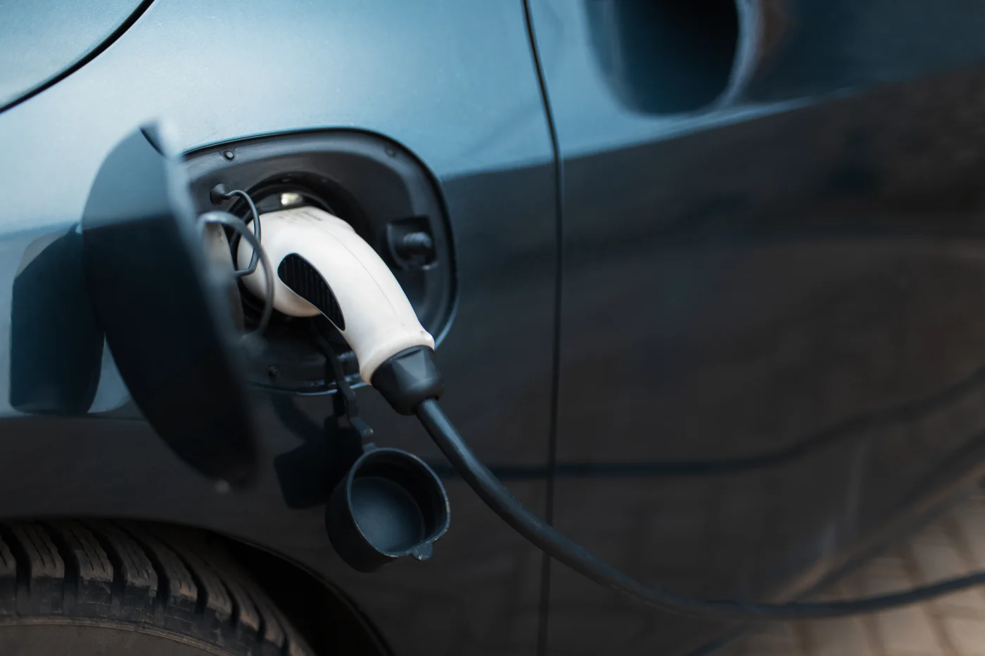 Gray Electric Car Plugged In And Charging At Home