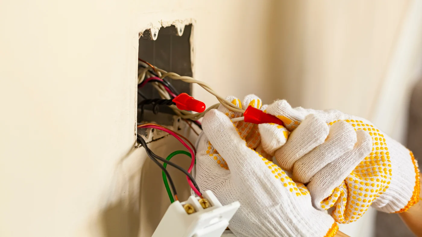 An electrician wires an outlet
