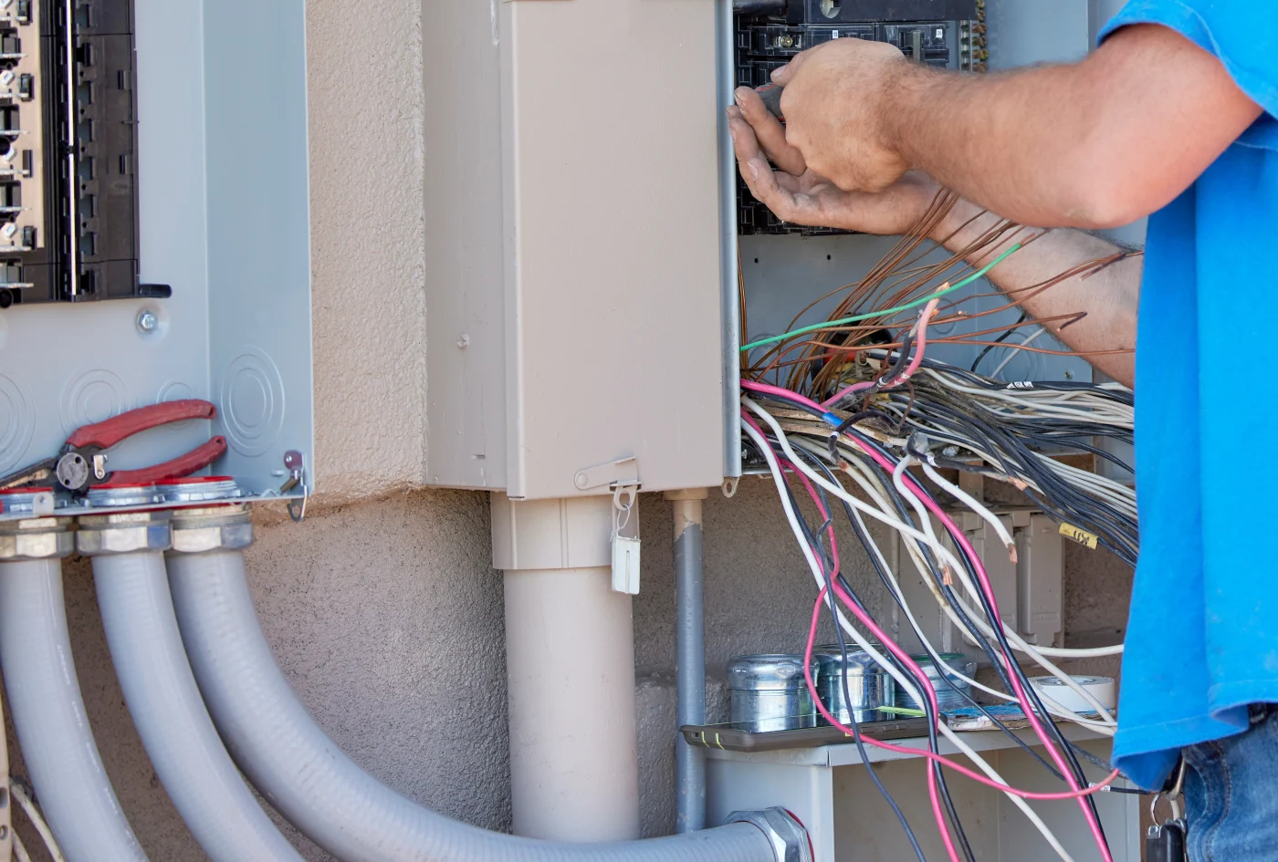Electrician working on wiring at breaker box