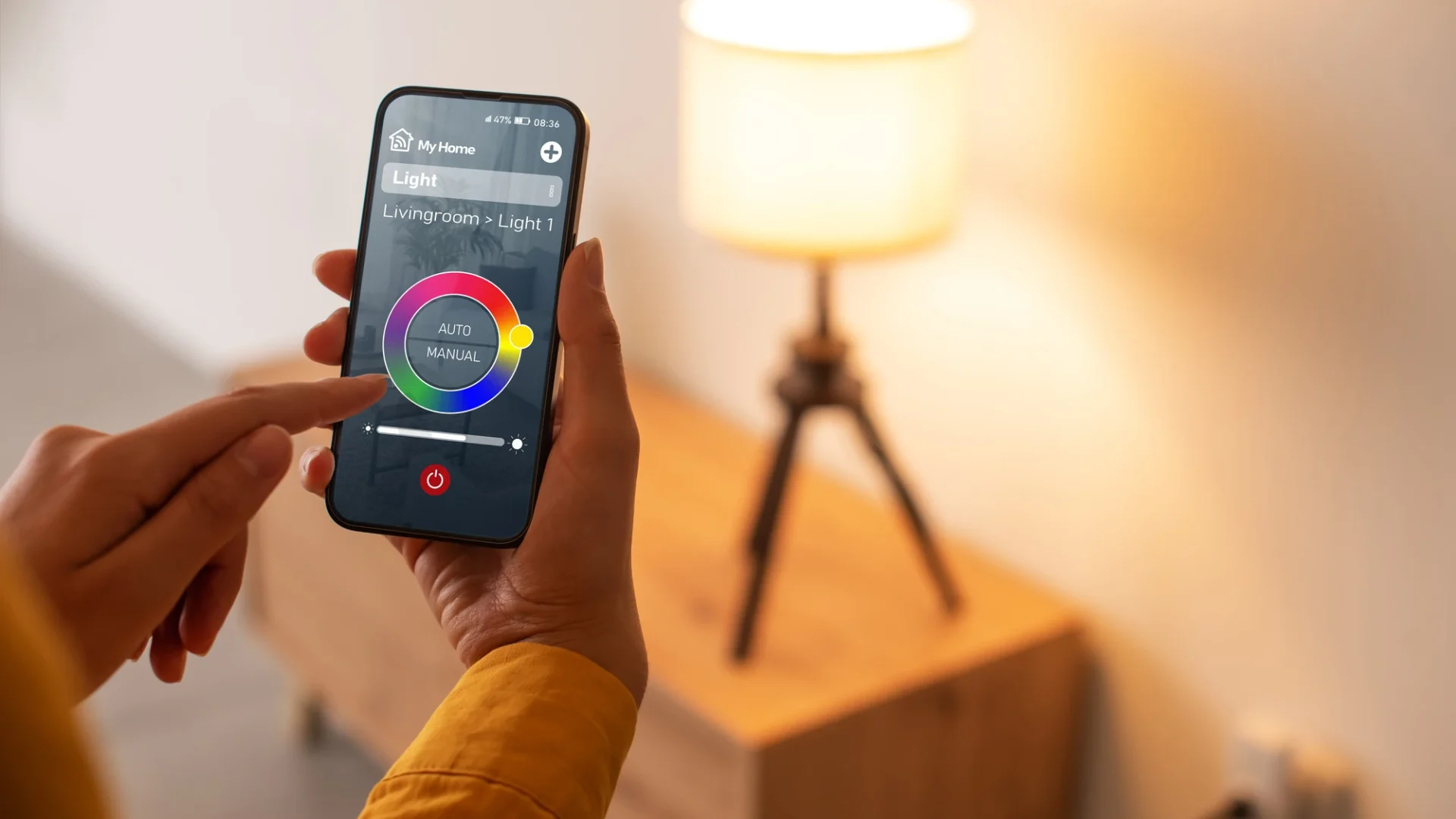 Close view of a homeowner controlling a table light with a smartphone app