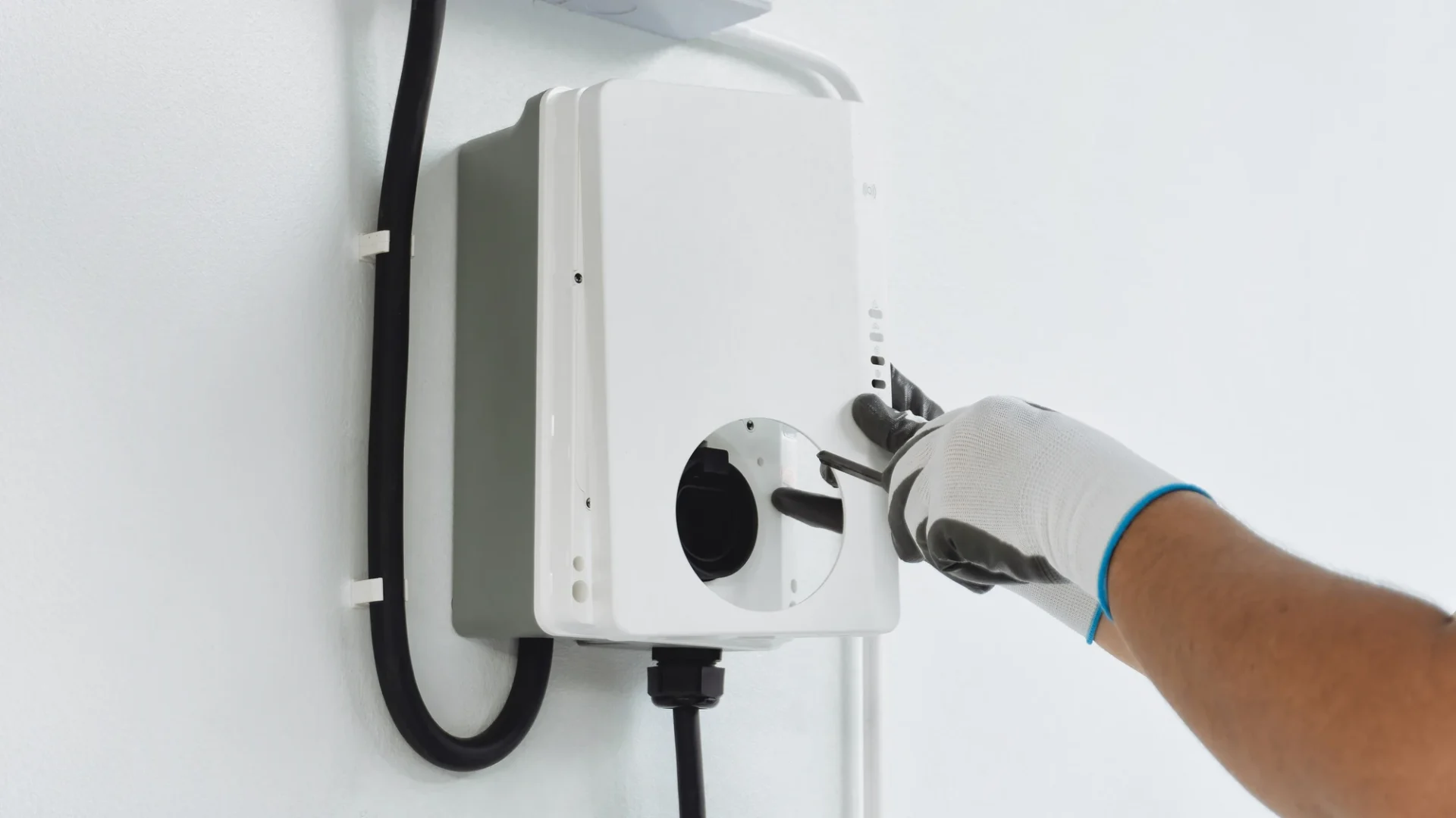 Worker installing a new electric vehicle charger in garage