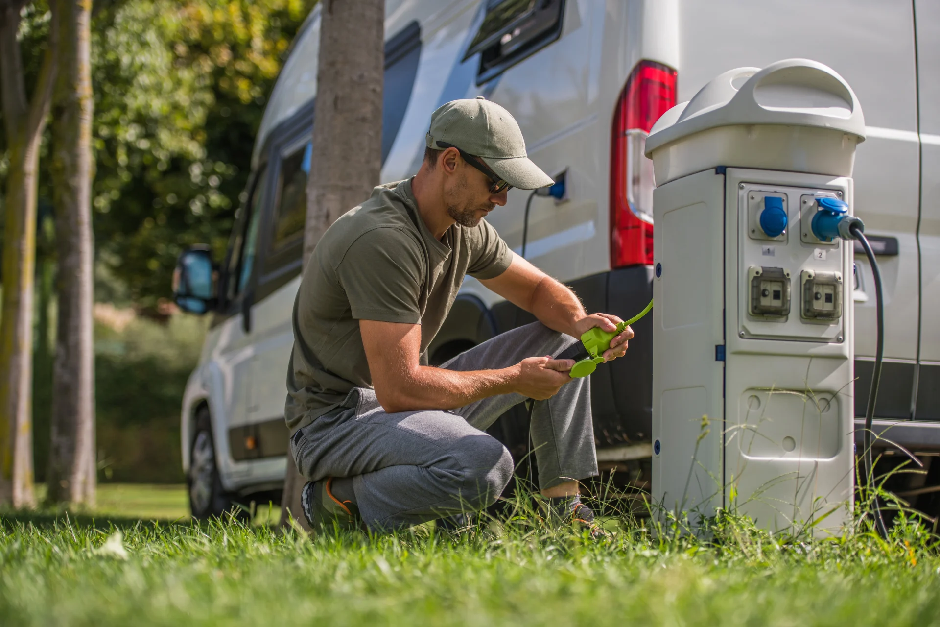 A man inspects his RV hookup, trying to diagnose an electrical issue with the RV.