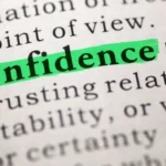 Close-up of a dictionary page with the word “Confidence” highlighted in green marker