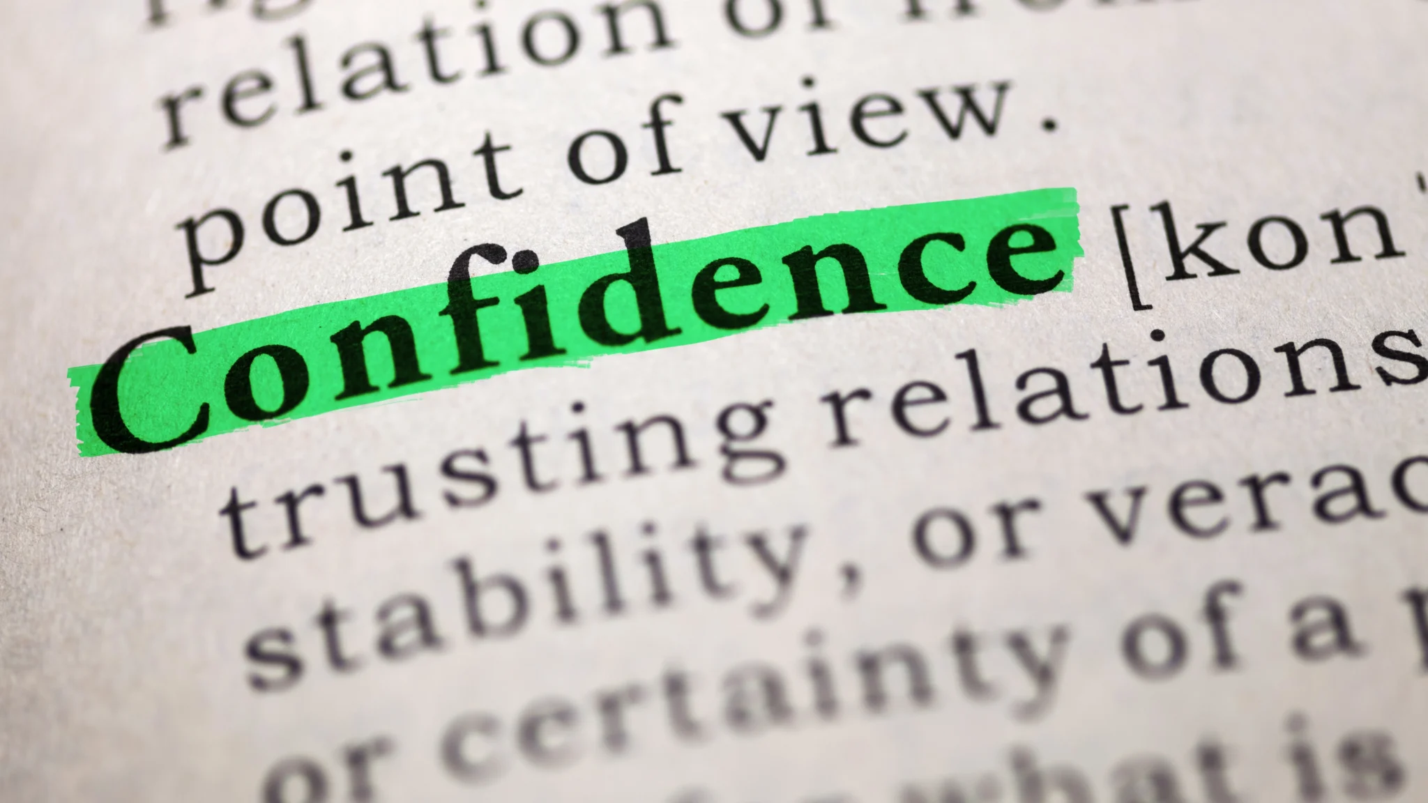 Close-up of a dictionary page with the word “Confidence” highlighted in green marker