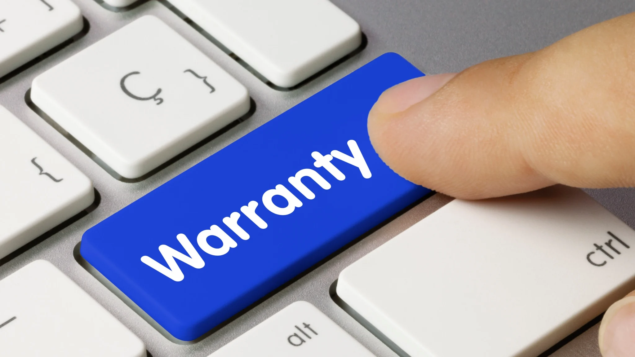 Close view of a computer keyboard with a finger poised above a big blue key inscribed with “Warranty” in white letters